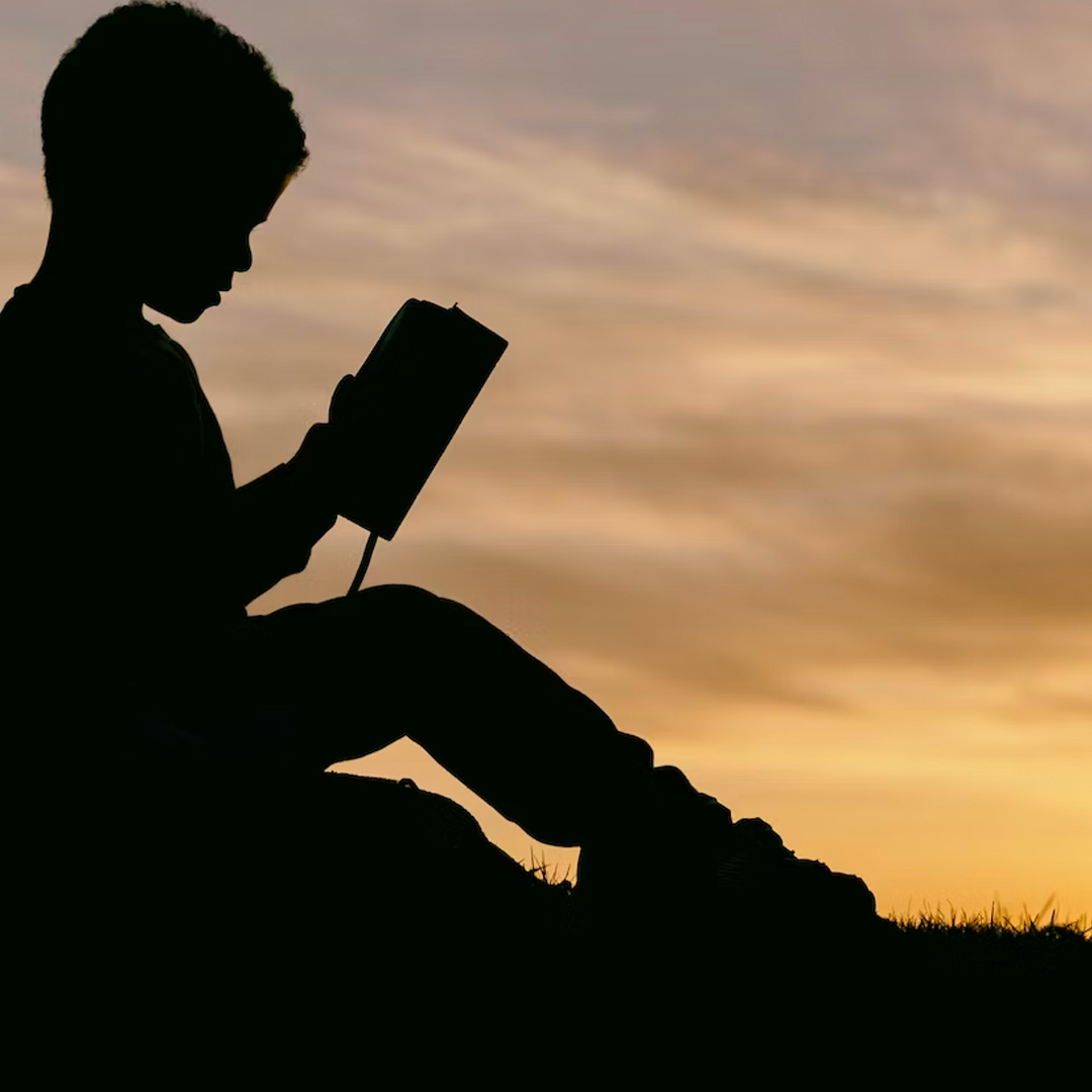 Child reading at dusk