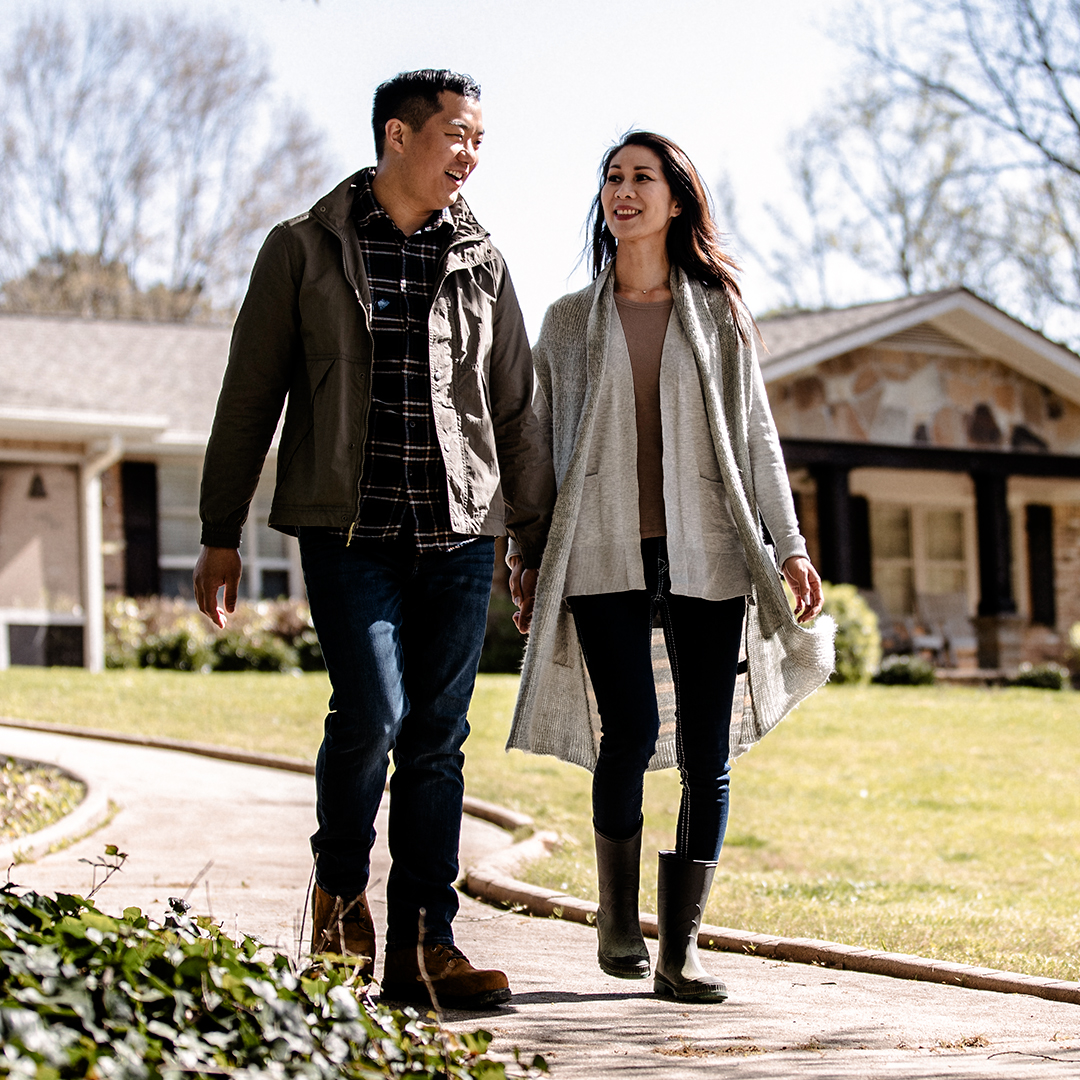 Couple holds hands in driveway