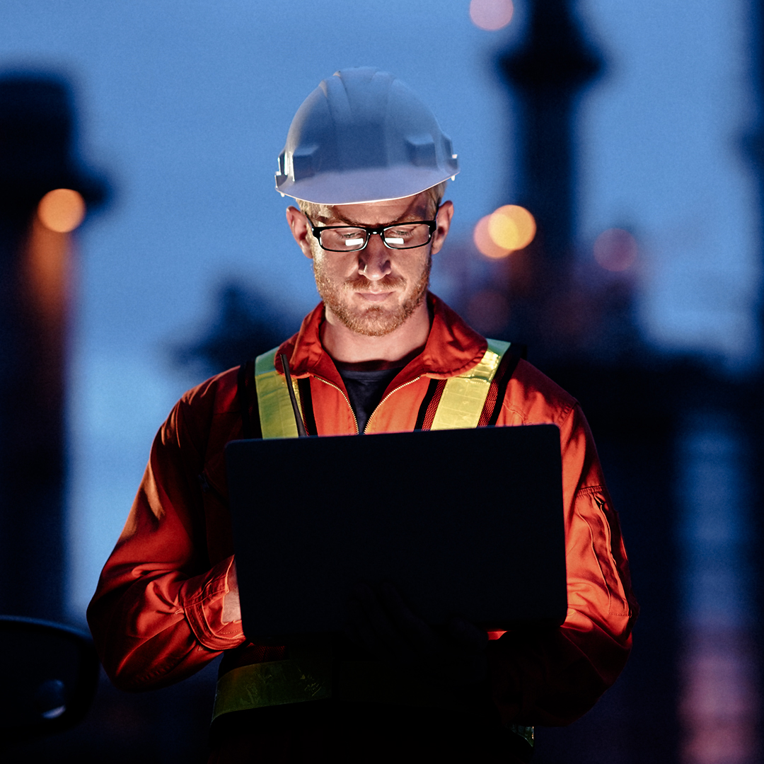 Man in hardhat on computer