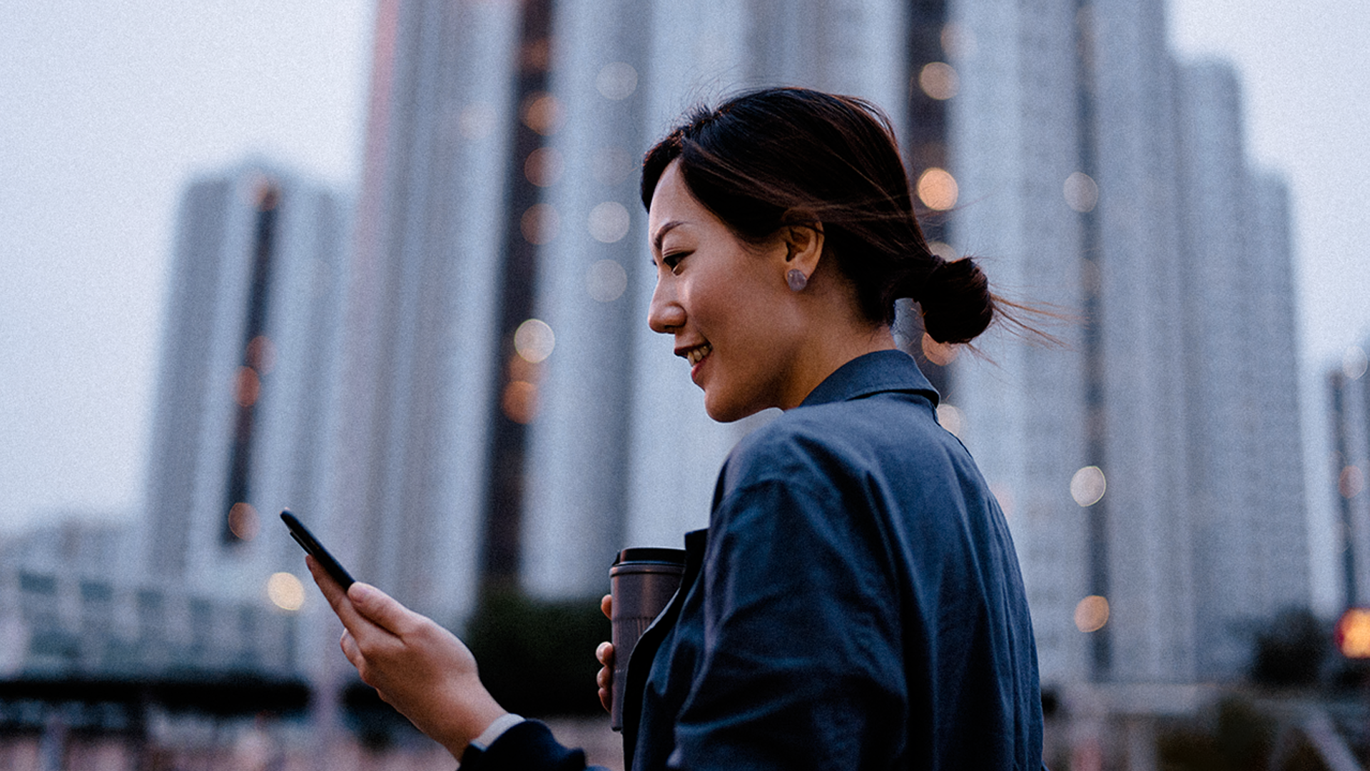 woman on phone in front of buildings