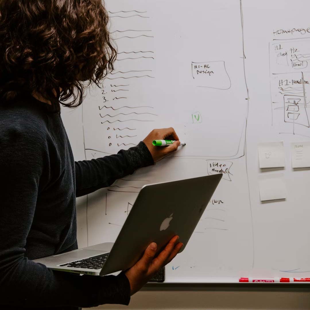 Woman draws on whiteboard