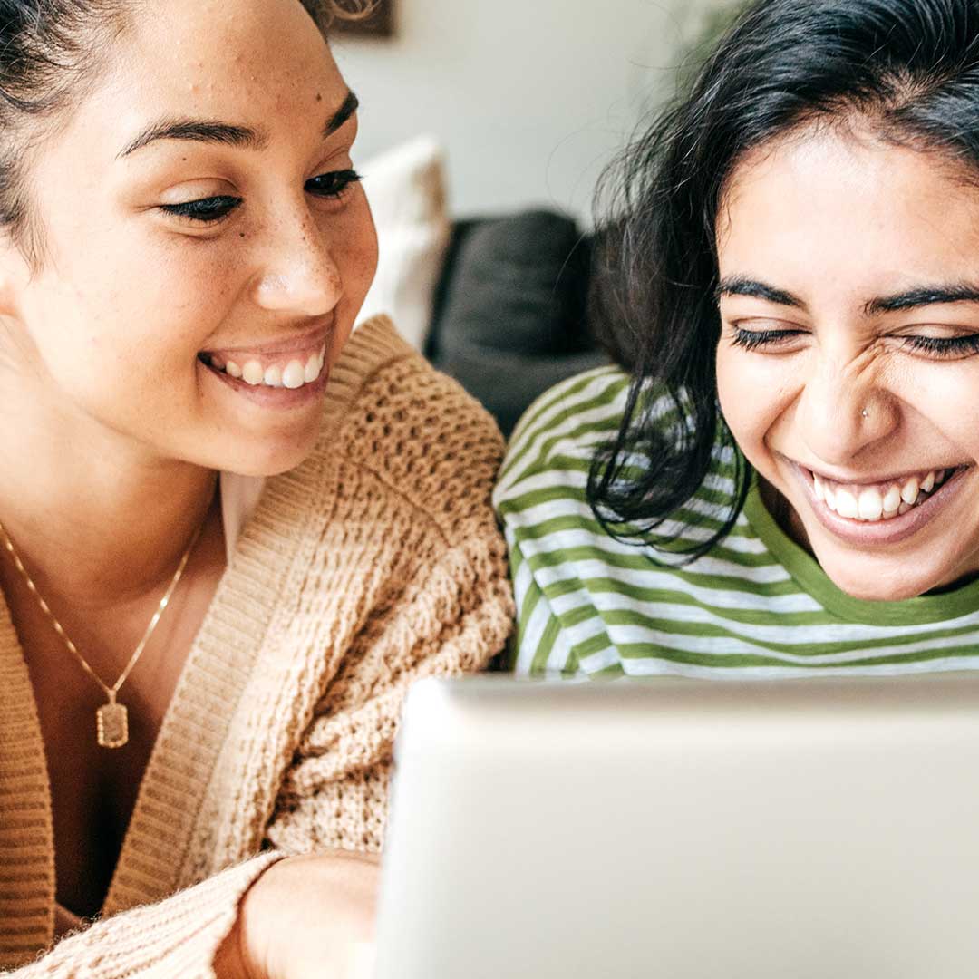 Women giggling near computer