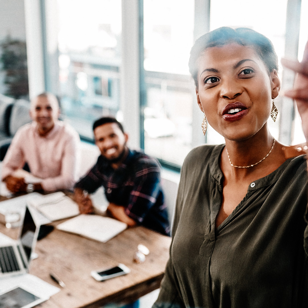 Woman points at glass board