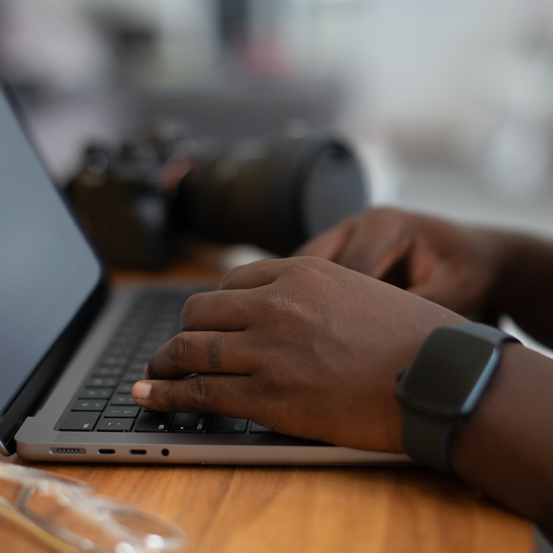 Hands typing on laptop