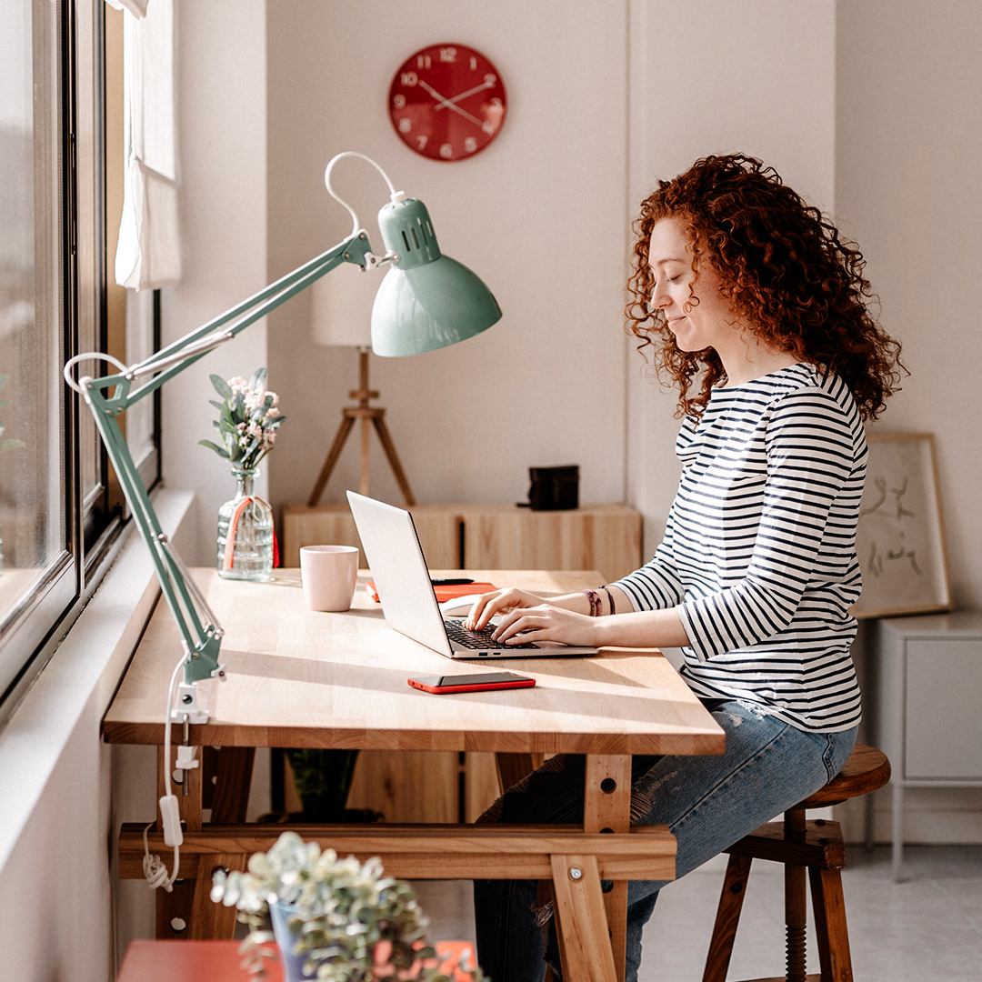 Woman works at wooden desk