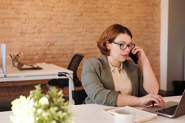 Woman sitting at a desk talking on phone